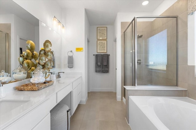 full bath with double vanity, a stall shower, a sink, tile patterned floors, and a bath