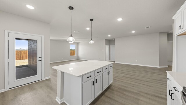 living room with a ceiling fan, recessed lighting, light wood-style floors, and baseboards