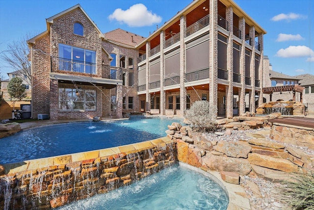 back of property with brick siding and a balcony