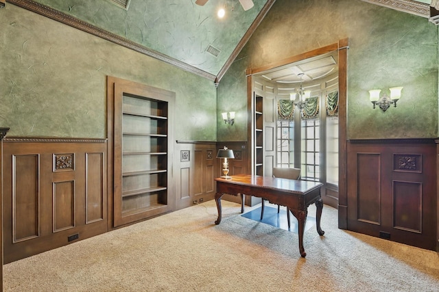 carpeted office space featuring built in features, crown molding, a decorative wall, and high vaulted ceiling