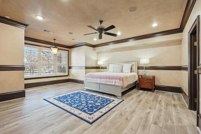 bedroom with crown molding, visible vents, and wood finished floors