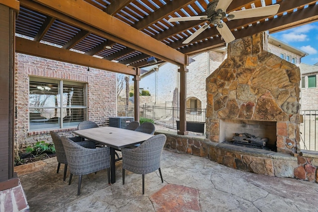 view of patio / terrace with a ceiling fan, fence, outdoor dining area, an outdoor stone fireplace, and a pergola