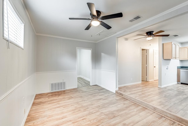 unfurnished room featuring light wood finished floors, visible vents, and crown molding