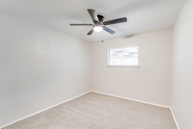 carpeted empty room with baseboards and a ceiling fan