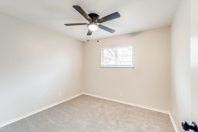 carpeted empty room featuring a ceiling fan and baseboards