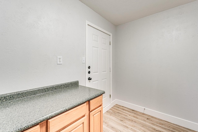 interior space with light wood finished floors and baseboards