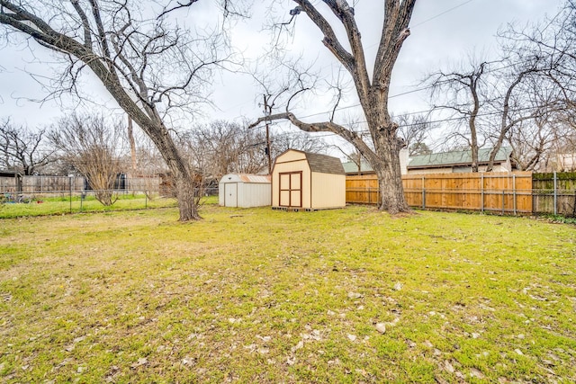 view of yard with a storage shed, an outdoor structure, and a fenced backyard