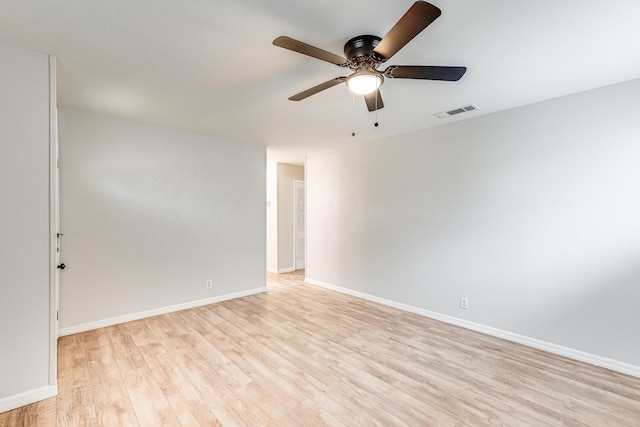 spare room featuring a ceiling fan, light wood-style flooring, visible vents, and baseboards