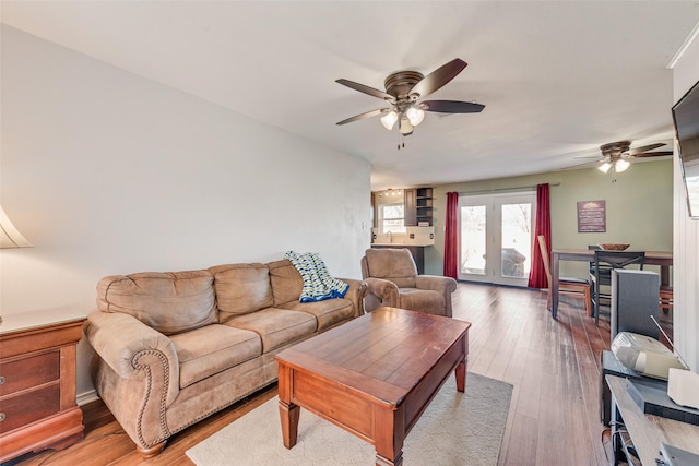 living area with a ceiling fan and wood-type flooring