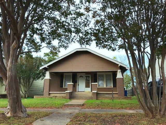 view of front of home featuring brick siding and a front yard