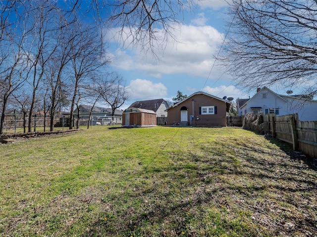 view of yard featuring a storage shed, an outdoor structure, and a fenced backyard