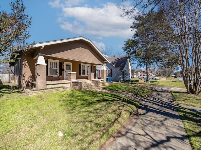 view of front of home with a porch, a front yard, and brick siding