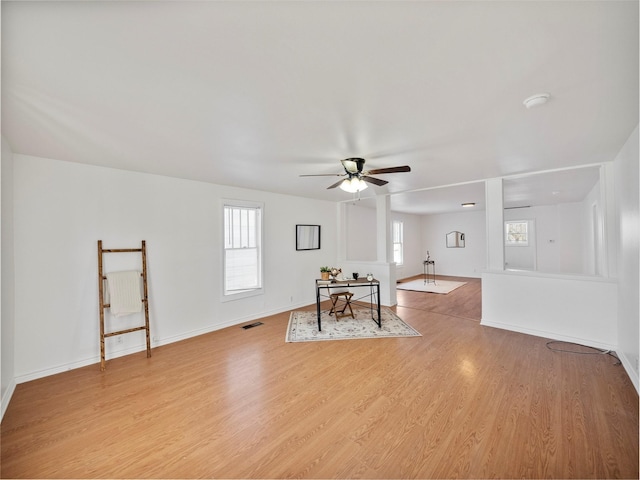 interior space with light wood-style floors, plenty of natural light, baseboards, and ceiling fan