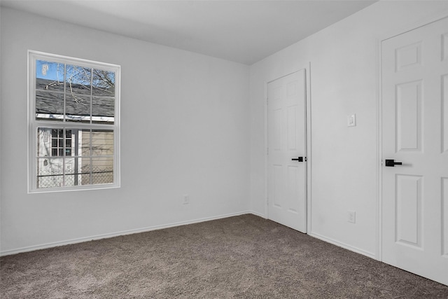 empty room with plenty of natural light, carpet flooring, and baseboards