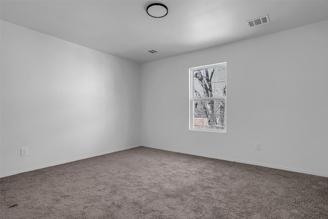 unfurnished room featuring baseboards, visible vents, and carpet flooring