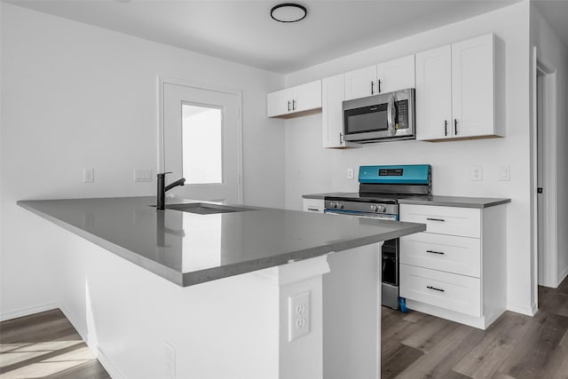 304 S 3rd, Bonham, TX 75418 - kitchen featuring stainless steel appliances, a sink, wood finished floors, and white cabinetry