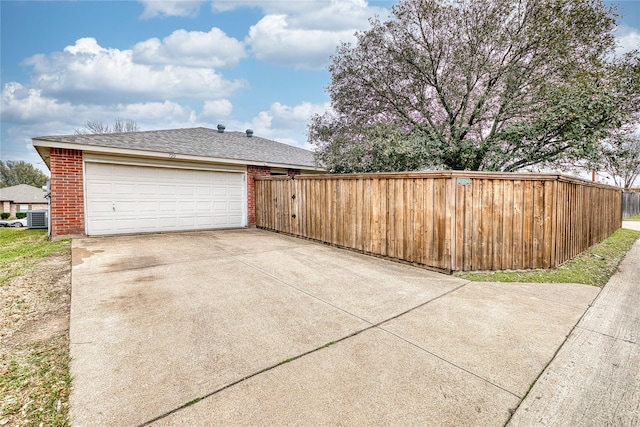 exterior space featuring a garage, driveway, brick siding, and roof with shingles