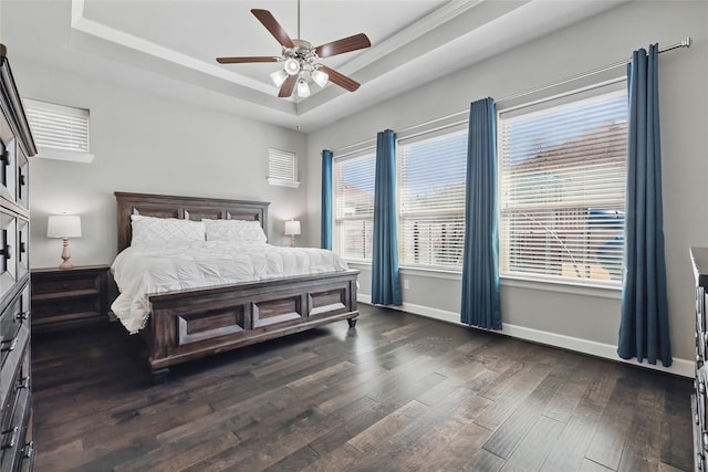 bedroom featuring baseboards, a ceiling fan, a tray ceiling, and dark wood-style flooring