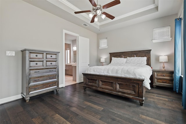 bedroom featuring visible vents, baseboards, a tray ceiling, and wood-type flooring