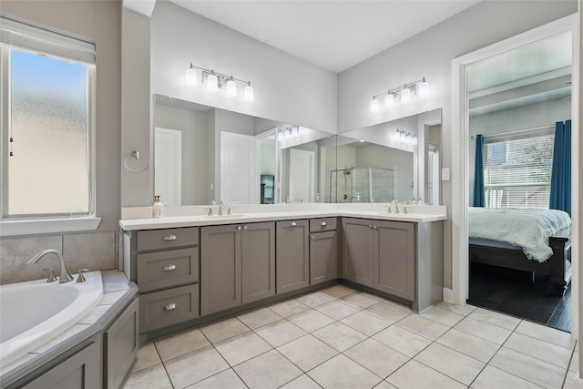 full bathroom featuring a stall shower, connected bathroom, tile patterned flooring, a bath, and vanity