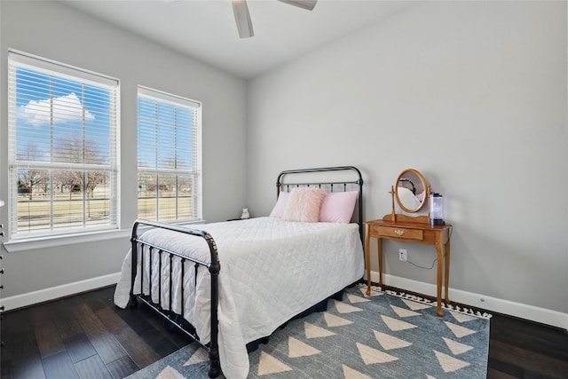 bedroom with ceiling fan, baseboards, and wood finished floors