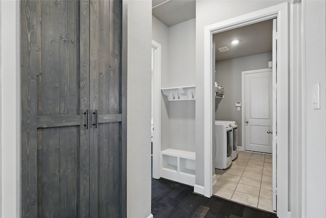 laundry room with wood finished floors, visible vents, baseboards, laundry area, and separate washer and dryer