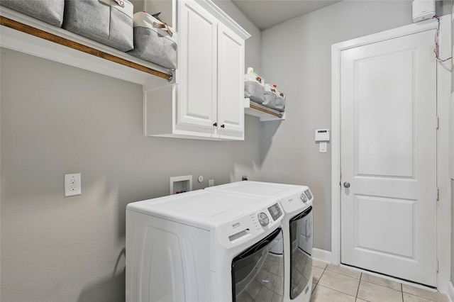 laundry room with light tile patterned floors, cabinet space, and independent washer and dryer