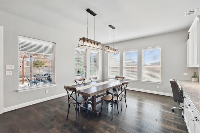 dining area featuring dark wood-style floors, visible vents, and baseboards