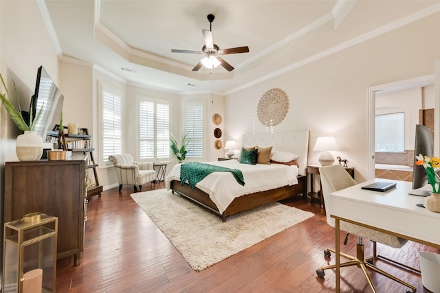 bedroom featuring a tray ceiling, dark wood-type flooring, visible vents, and crown molding