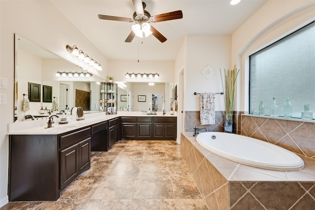 bathroom with a garden tub, double vanity, a sink, and a ceiling fan