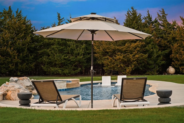 outdoor pool with an in ground hot tub and a yard