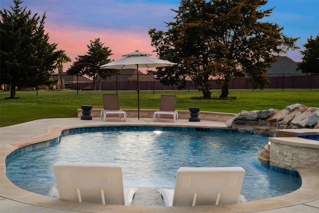 pool at dusk with a fenced in pool, a yard, and fence