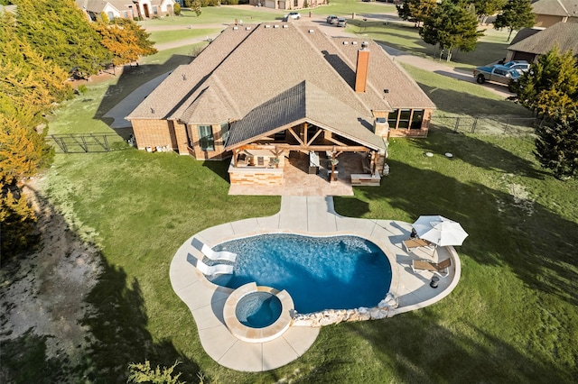 view of pool featuring a pool with connected hot tub, a fenced backyard, a patio, and a lawn