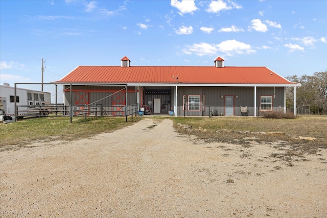 view of front of property with metal roof, an exterior structure, and an outdoor structure