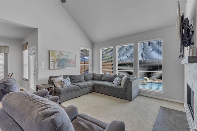 living room with carpet, a fireplace with flush hearth, high vaulted ceiling, and baseboards