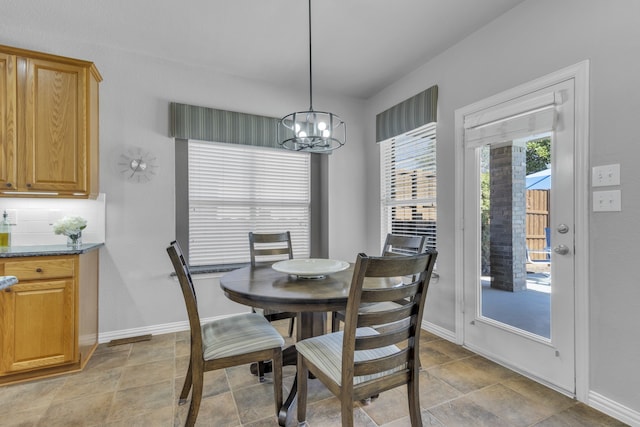 dining space with a chandelier and baseboards