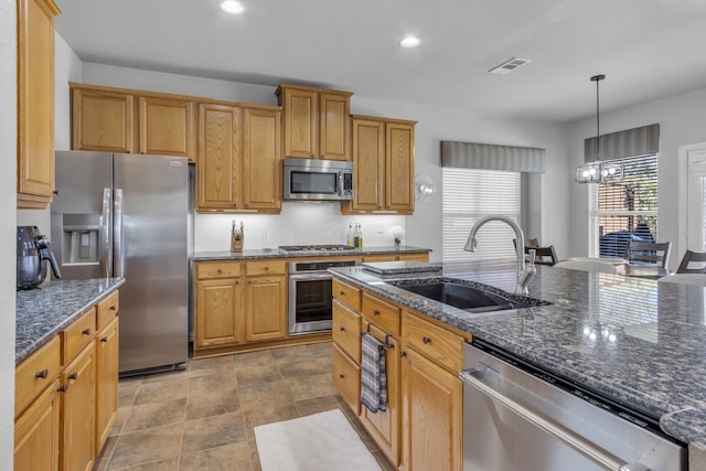 kitchen featuring visible vents, decorative backsplash, appliances with stainless steel finishes, decorative light fixtures, and a sink