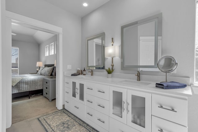 full bath featuring connected bathroom, tile patterned flooring, a sink, and double vanity