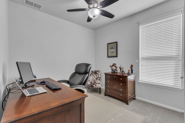 office space featuring a ceiling fan, visible vents, light carpet, and baseboards