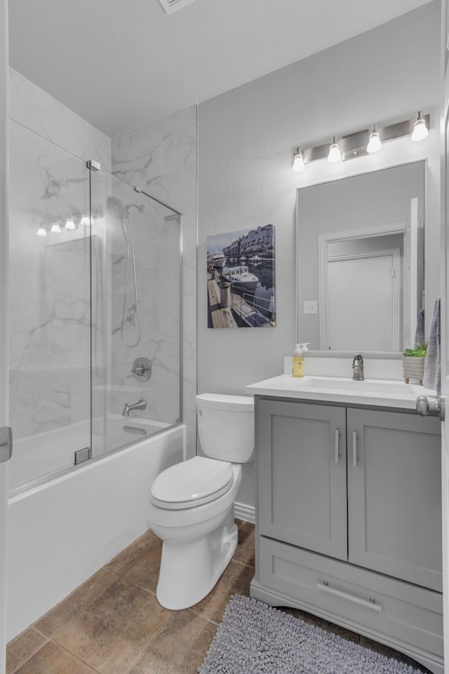 bathroom with enclosed tub / shower combo, vanity, and toilet