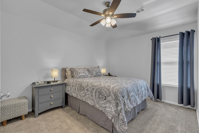 bedroom featuring a ceiling fan, light carpet, visible vents, and baseboards