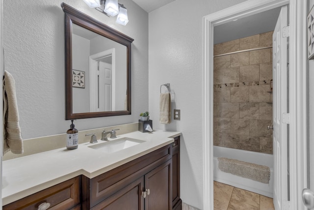 full bathroom featuring tile patterned flooring, tub / shower combination, a textured wall, and vanity