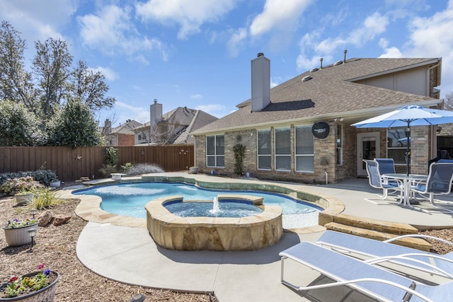 view of pool featuring a fenced backyard, a pool with connected hot tub, and a patio