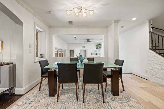 dining area with ornamental molding, wood finished floors, visible vents, and baseboards