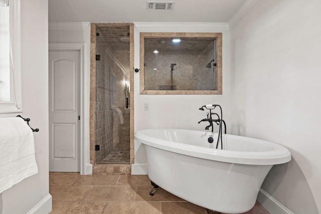 bathroom featuring a stall shower, baseboards, visible vents, crown molding, and a freestanding tub