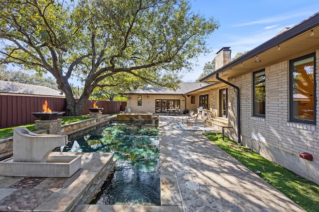 view of swimming pool with a fenced in pool, an outdoor fire pit, a patio area, and a fenced backyard