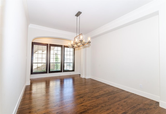 empty room featuring baseboards, an inviting chandelier, dark wood finished floors, and crown molding