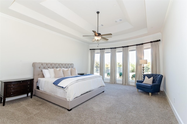 carpeted bedroom with crown molding, a tray ceiling, visible vents, and baseboards