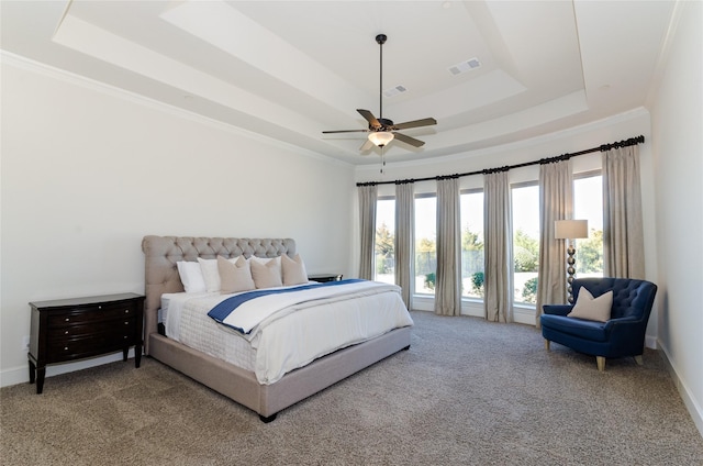 carpeted bedroom with crown molding, visible vents, and a raised ceiling