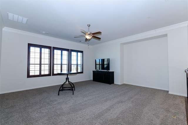 carpeted spare room with baseboards, ornamental molding, visible vents, and a ceiling fan